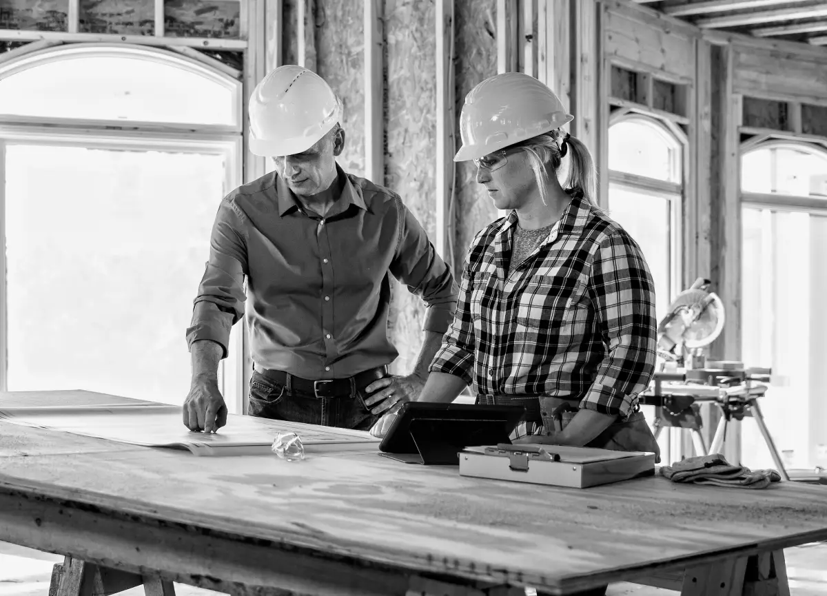 Man in construction hardhat and safety glasses looking at camera