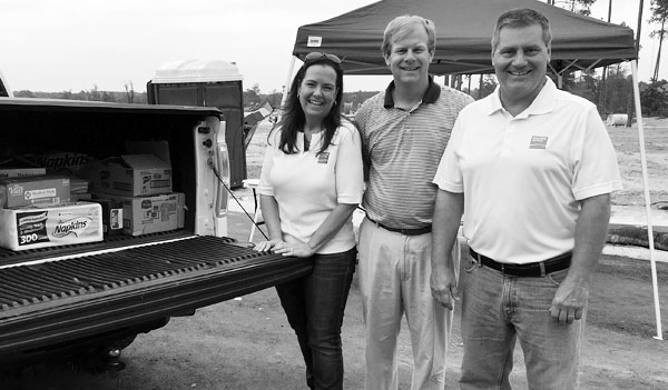 Smiling people at construction event by pickup truck